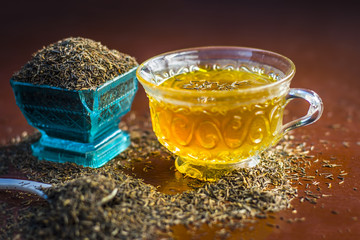 Black cumin seeds,shah jerra,Nigella sativa  and its tea on brown wooden surface.;