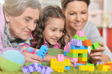 Obraz na płótnie Canvas family playing with colorful plastic blocks