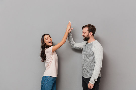 Portrait Of A Cheery Young Couple Giving High Five