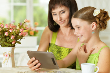mother and daughter using tablet