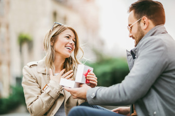 Couple in love.Man surprising his girlfriend with a gift.