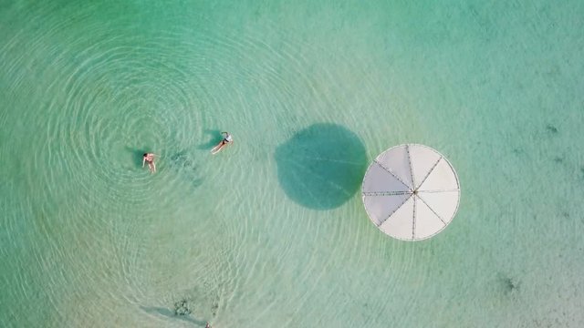 Top down aerial footage of people floating in the salty water of the Dead Sea, Israel.