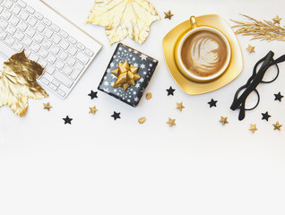 Gold coffee cup with glasses and keyboard isolated on white. Flat lay, top view, copy space