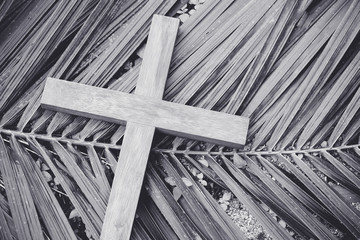wooden cross on palm leaf.Palm sunday and easter day concept.black and white.