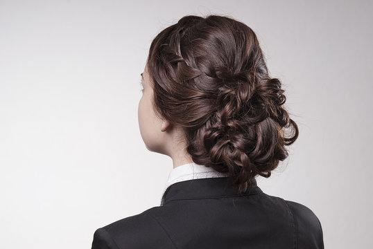 Head Of Woman With Brown Hair In Bun On Gray Isolated Background Rear View Head Turning To The Left