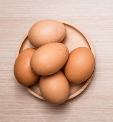 Close-up view of chicken eggs on wooden table background
