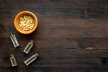 Fototapeta na wymiar Oil for skin care. Peanut oil on dark wooden background top view copy space