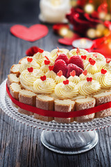 Cake with butter cream and fresh raspberries for Valentine's Day or mother's day on black wooden background, Copy space, top view.
