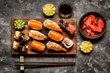  sushi and sushi rolls, sushi nigiri on stone plate on dark background, mustard wasabi, and ginger © Наталья Майорова