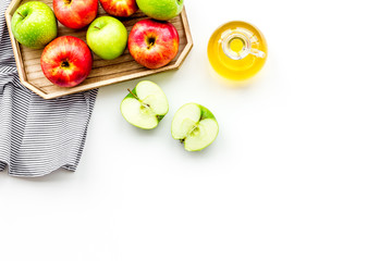 Apple cider vinegar in bottle among fresh apples on white background top view copy space