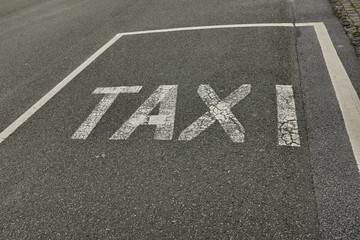 Taxi, marquage blanc au sol sur goudron noir