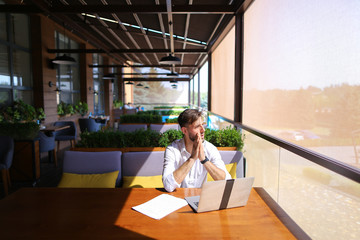 Inventory strategist working with laptop at cafe table.
