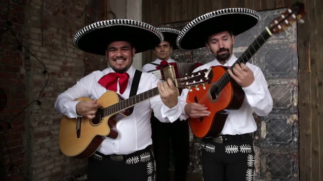 Mexican musician mariachi playing guitar and accordion in the studio