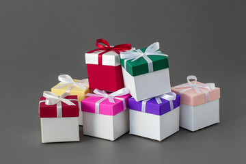 Several colorful gift boxes with ribbons on gray background.