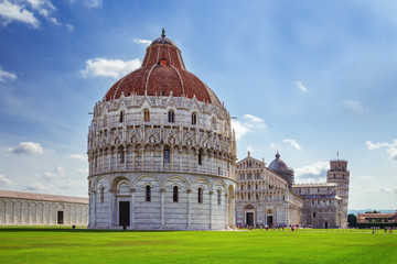The Pisa Baptistery with the Cathedral and Leaning Tower of Pisa. Italy, June 2017. Famous Italian architecture.