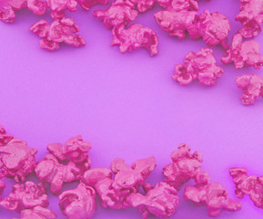 Pink popcorn on purple paper background. Fashion pop art style. Top view.
