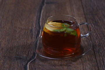 Glass cup with lemon and mint tea