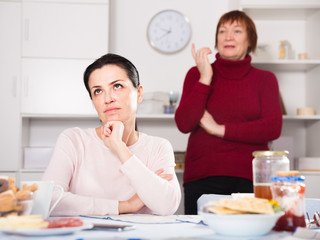 Mature female talking with young sad daughter