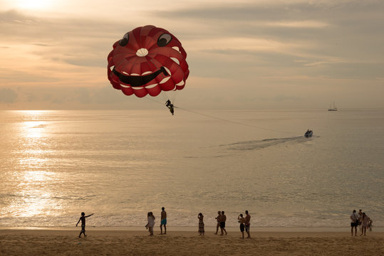 Parasailing on the beach in sunset