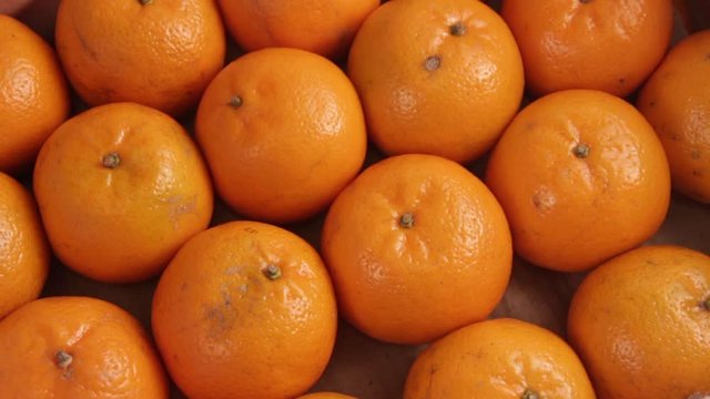 The box under the packing sheet of paper tangerines of poor quality. Close-up. Deception of consumers. The concept of a rotten citrus crop. Full HD video.