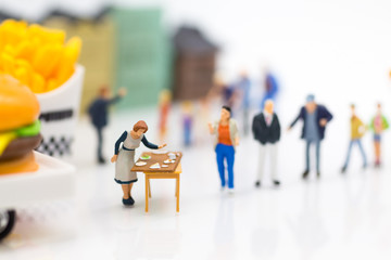 Miniature people : Traders are preparing food for customers who queue up the queue. Image use for business food concept.