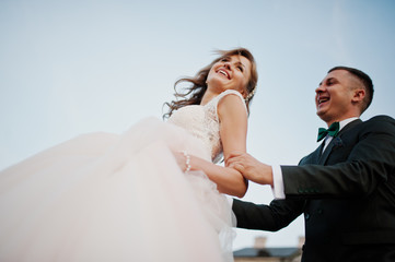 Fabulous wedding couple posing in front of an old medieval castle in the countryside on a sunny day.