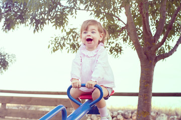 Niña pequeña feliz jugando en un parque 