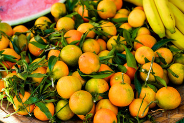 Close up of different exotic fruits at fairy at Ibiza island. Bananas, tangerines, pumpkin, grapes and peach. Eco and raw product for vega. 