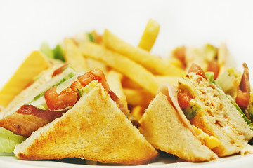 Club Sandwich with Cheese, Tomato and Smoked Meat. Garnished with French Fries