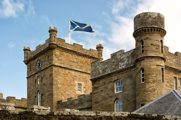 Towers of Calzean castle with Scottish flag waving in the breeze, Scotland, UK