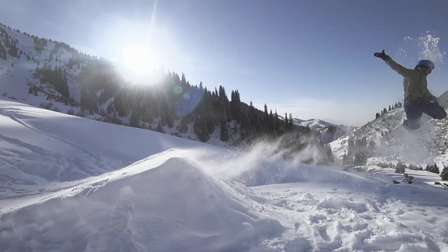Slow motion footage of Snowboarder doing high jump at mountain