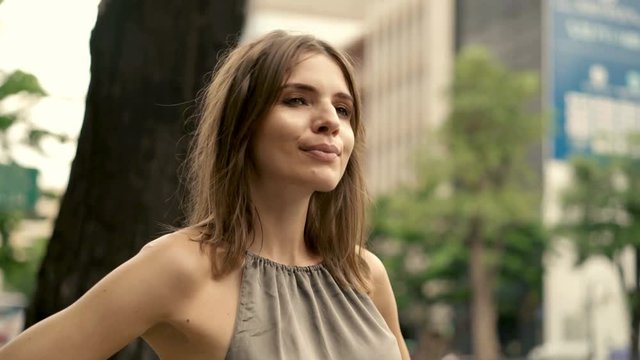 Happy, beautiful woman standing in the city 4K
