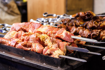 The process of cooking shish kebab on a metal grill in the open air.Grilling shashlik on barbecue grill. Marinated meat.