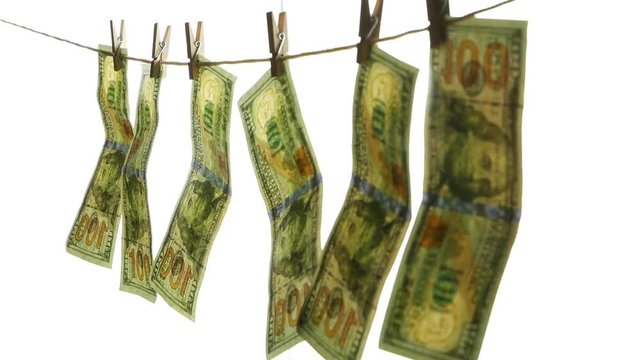 Dollar banknotes hang on a rope with clothespins. The concept of dirty money