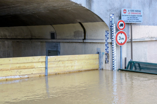 Flood markers and road signs at the entrance of a tunnel flooded by the important rise in the water level of the river Marne.