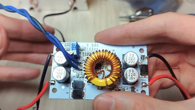 The man adjusts the operation of the LED, connects the power. Repair of electronic devices, tin soldering parts.
