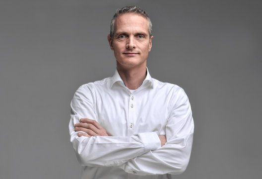 Portrait Of A Man In A Shirt On A Gray Background.