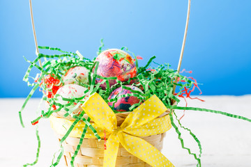 Photo of basket with colorful eggs