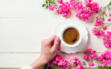 Girl having a cup of tea on table with roses