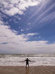 Silhouette of the young man on the beach. Freedom concept.