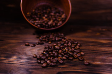 Roasted coffee beans in bowl on wooden table