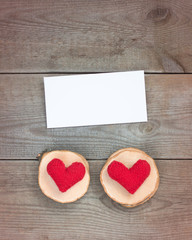 Two handmade red knitted hearts on the wooden background. Valentine's or Wedding's day postcard concept.