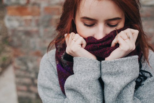 красивая молодая девушка в пальто закуталась в шерстяной шарф beautiful young girl in a coat wrapped in a wool scarf