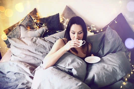 junge Frau im Bett mit Tasse Schlafzimmer Frühstück