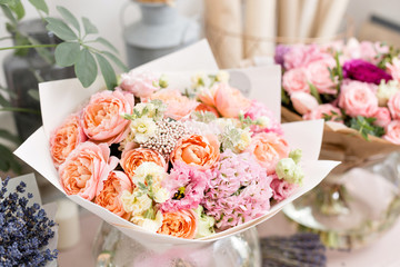 Few of beautiful luxury bouquet. Mixed flowers on pink table. the work of the florist at a flower shop. Wedding