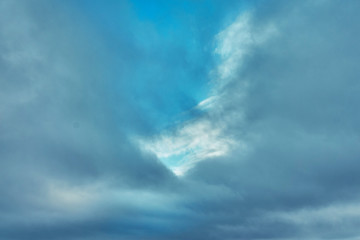 Gray clouds on a blue winter sky with a sunlit
