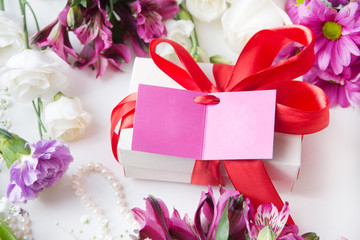 gift or present box with note and flowers on white table look with top. Womans or Mothers Day.