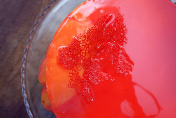 Mirror red Glazed Cream Cake. Homemade Dessert with Strawberry and with Iced berries. Top view over Wooden Table.