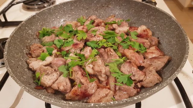 Finely chopped pieces of pork with onion and spices fry in oil on the stove
