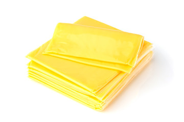 Slices of processed cheese on a white background. Square slices of cheese for a burger close-up.
